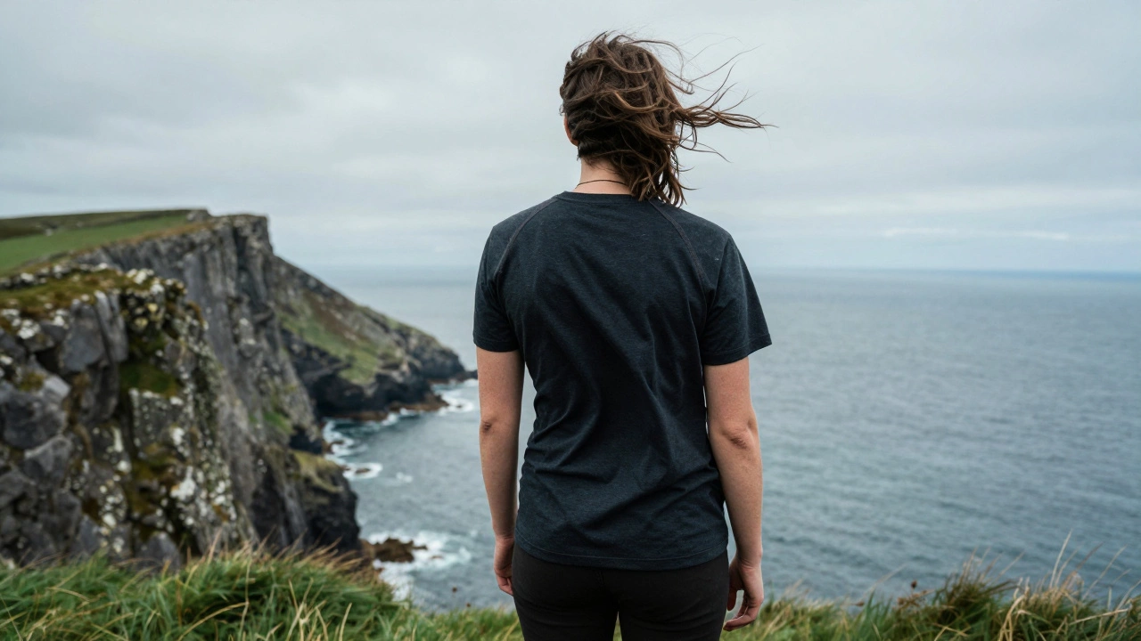 Hiker in durable t-shirt on windy Irish cliff overlooking sea